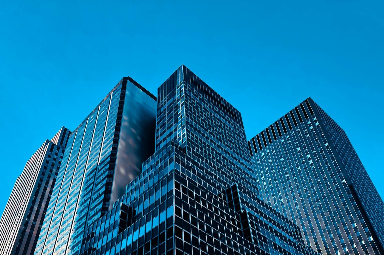 Glass office towers against a blue sky